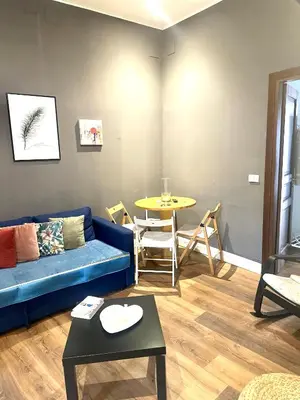 a living room with a blue couch and a table at Porta di Castro's Home in Palermo