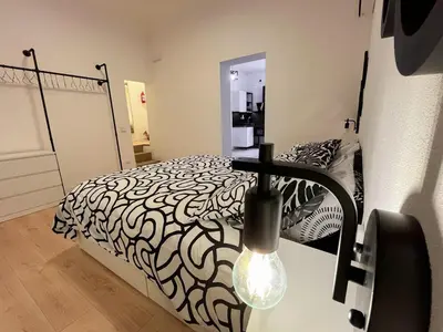a bedroom with a black and white bed and a light at Oasi urbana Palermo in Palermo