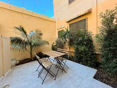 a patio with a table and chairs and a building at Oasi urbana Palermo in Palermo