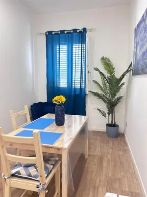 a dining room with a table and a blue curtain at Dimora dell'Olivella 2 in Palermo