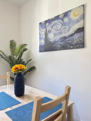 a dining room table with a painting on the wall at Dimora dell'Olivella 2 in Palermo