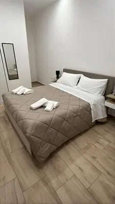 a bedroom with a large bed with two towels on it at Daimana holiday apartament in Palermo