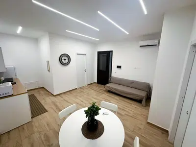 a living room with a table and a couch at Daimana holiday apartament in Palermo