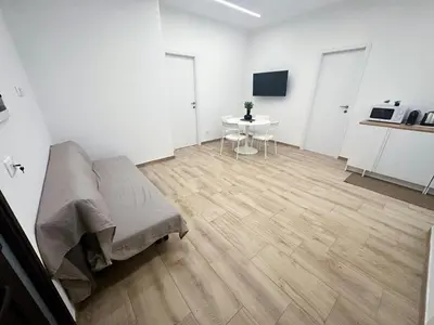 a white room with a bed and a table at Daimana holiday apartament in Palermo