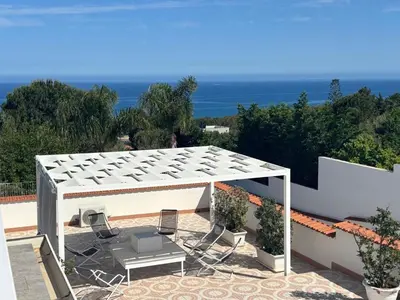 a patio with a white canopy and chairs and the ocean at Holiday Home Casa Gaetano by Interhome in Balestrate