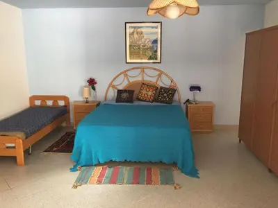 a bedroom with a bed with a blue bedspread on it at Apartment Villa Gina in Trappeto by Interhome in Trappeto