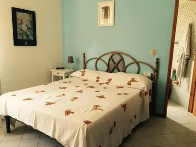 a bedroom with a bed with a white comforter at Holiday Home Villa Aliotis 200m vom Meer entfernt by Interhome in Alcamo Marina