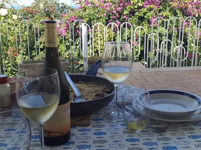 a bottle of wine and two glasses on a table at Holiday Home Villa Aliotis 200m vom Meer entfernt by Interhome in Alcamo Marina