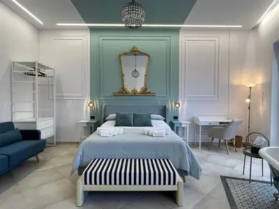 a kitchen with white cabinets and a stove top oven at Palermo City Garden Lux Suites in Palermo
