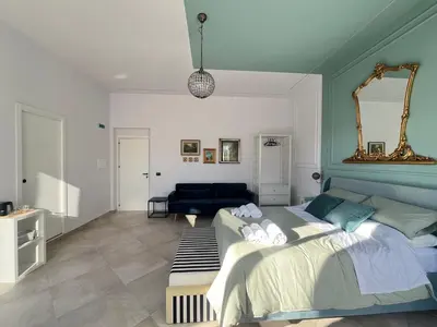 a hotel room with a bed and a bathroom at Palermo City Garden Lux Suites in Palermo