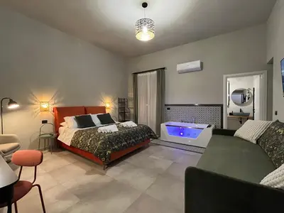 a living room with a table and a chandelier at Palermo City Garden Lux Suites in Palermo