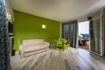 a living room with a couch and a table at APT RINO Sea View basement in Villa Rosaria in Scopello