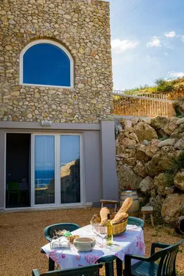 a table with food on it in front of a house at APT RINO Sea View basement in Villa Rosaria in Scopello