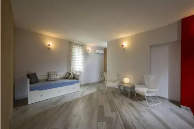a bedroom with a bed and chairs and a window at APT Marta in Villa Rosaria Vista Mare Zingaro in Scopello