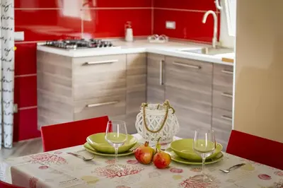 a kitchen with a table with two glasses of wine at APT Marta in Villa Rosaria Vista Mare Zingaro in Scopello