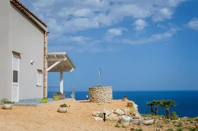 a house on the beach with the ocean in the background at APT Marta in Villa Rosaria Vista Mare Zingaro in Scopello