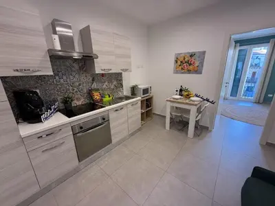 a kitchen with white cabinets and a table in it at palermo house in Palermo