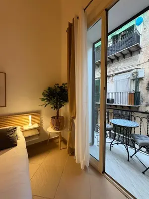 a bed with towels on it in front of a window at La Dimora dei Pupi - Centro Storico in Palermo
