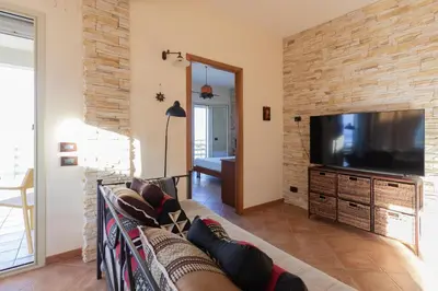 a living room with a couch and a flat screen tv at Visitsicilia Sabbia Dorata in Alcamo Marina