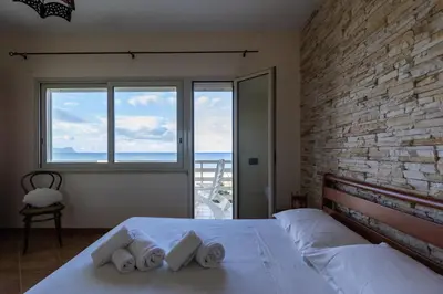 a bedroom with a white bed with a large window at Visitsicilia Sabbia Dorata in Alcamo Marina