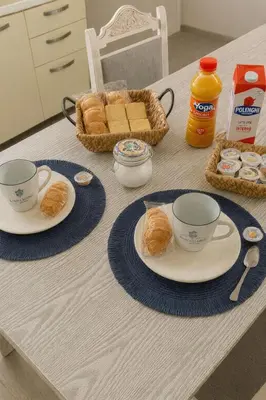 a table with two cups and plates of food and bread at Cattedrale stay in Palermo