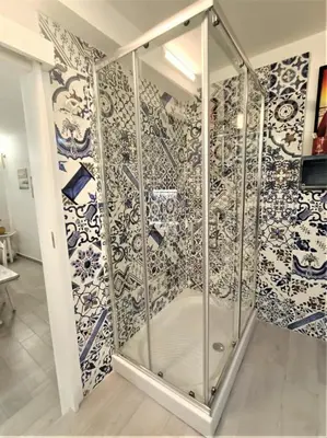 a shower in a room with blue and white tiles at Cattedrale stay in Palermo