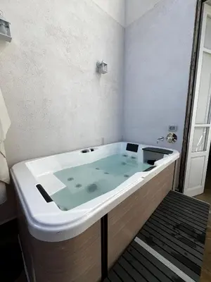 a table with two bottles of wine and a bowl of candy at Aromatika Suite in Palermo