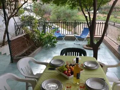 a table with a bowl of fruit and a bottle of wine at Apartment Wohnung mit Wasserblick by Interhome in Castellammare del Golfo