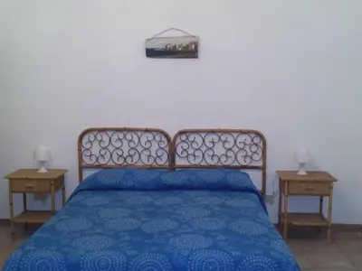 a bedroom with a blue bed with two night stands at Apartment Wohnung mit Wasserblick by Interhome in Castellammare del Golfo
