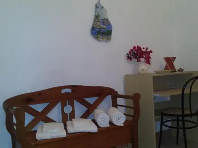 a wooden chair with white towels on it next to a desk at Apartment Wohnung mit Wasserblick by Interhome in Castellammare del Golfo