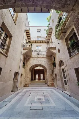 a courtyard with a grassy yard in a building at Hybrid Icon Rooms Gallery City Center in Palermo