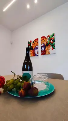 a bottle of wine and a plate of fruit on a table at Villa du Cori in Alcamo