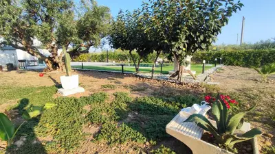 a park with a bench and some plants and trees at Villa du Cori in Alcamo