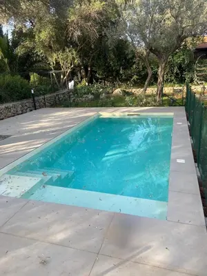 a swimming pool with blue water in a yard at iFlat Punta Catalana in Terrasini