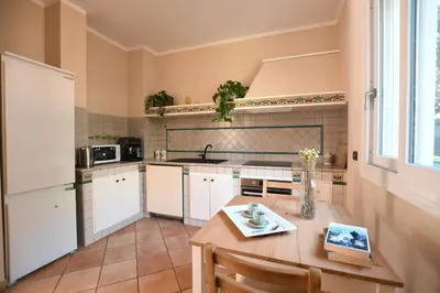a kitchen with a table and a white refrigerator at iFlat Punta Catalana in Terrasini