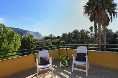 two chairs on a balcony with a view of mountains at iFlat Punta Catalana in Terrasini
