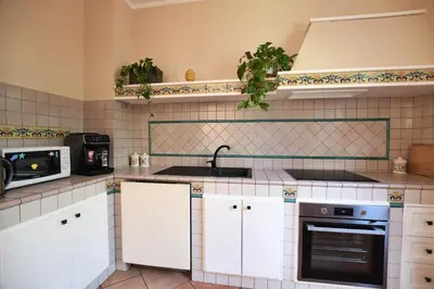 a kitchen with white cabinets and a sink and a stove at iFlat Punta Catalana in Terrasini