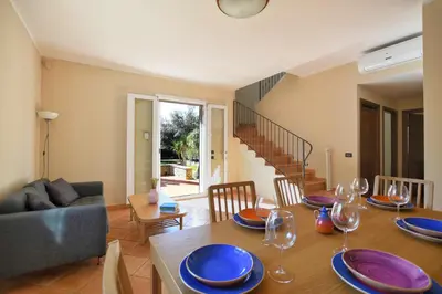 a dining room with a table with plates and wine glasses at iFlat Punta Catalana in Terrasini