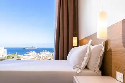 a bedroom with a bed with a view of the ocean at Skyline Boutique Hotel in Palermo