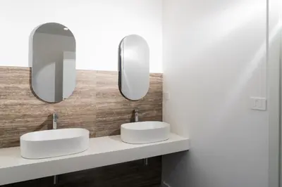 two sinks in a bathroom with two mirrors at Skyline Boutique Hotel in Palermo