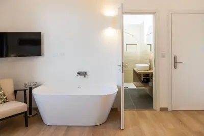 a bathroom with a white tub and a sink at Skyline Boutique Hotel in Palermo
