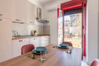 a kitchen and dining room with a wooden table and chairs at Ludohome in Palermo