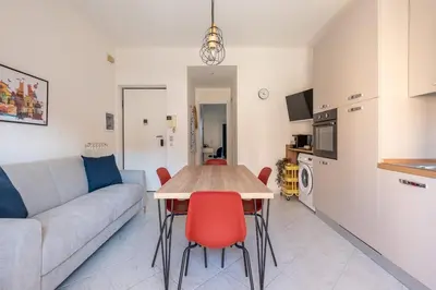 a living room with a couch and a table with red chairs at Ludohome in Palermo