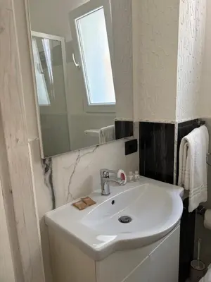 a bathroom with a white sink and a mirror at Casita Blanca in Santa Flavia