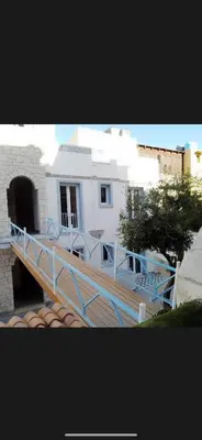a white house with a blue railing on a deck at Casita Blanca in Santa Flavia