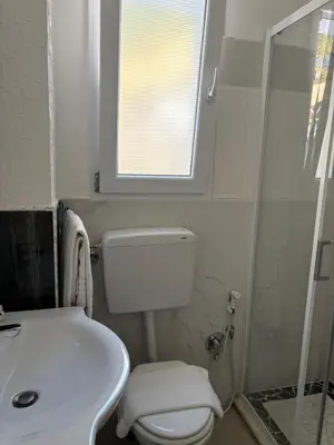 a bathroom with a toilet and a sink and a window at Casita Blanca in Santa Flavia