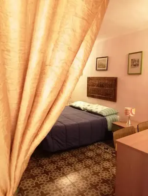 a bedroom with a bed and a curtain at Tomicla in Monreale