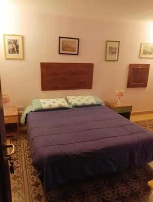 a bedroom with a large purple bed in a room at Tomicla in Monreale