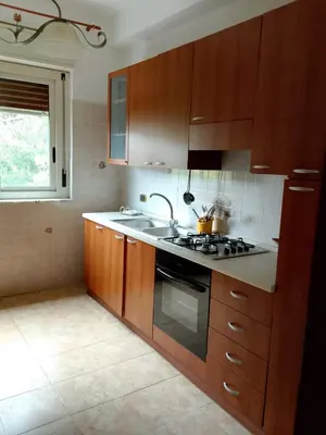 a kitchen with wooden cabinets and a sink and a stove at Altofonte Vista in Altofonte