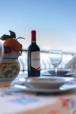 a bottle of wine and a glass on a table at casavacanzabordonaro in Palermo